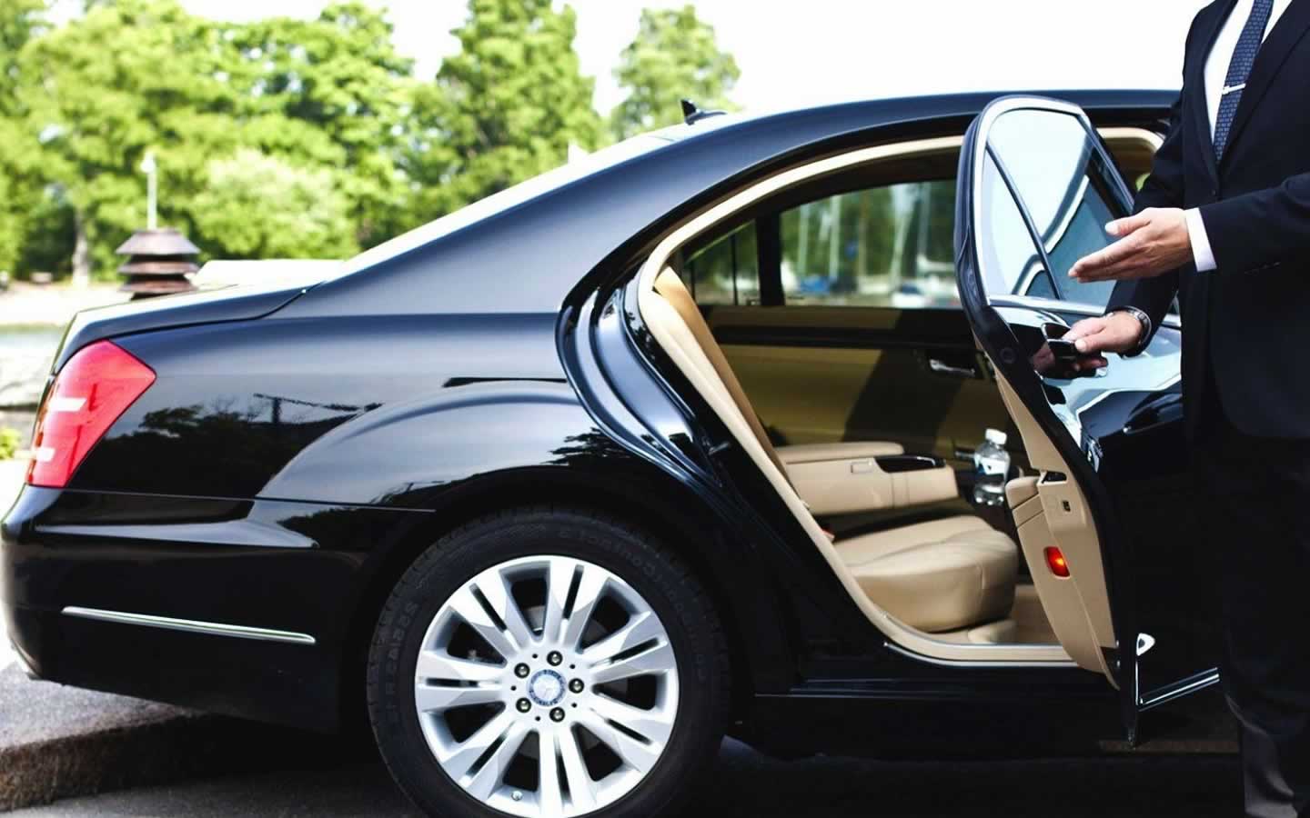 Chauffeur opens the door of a business limo hire