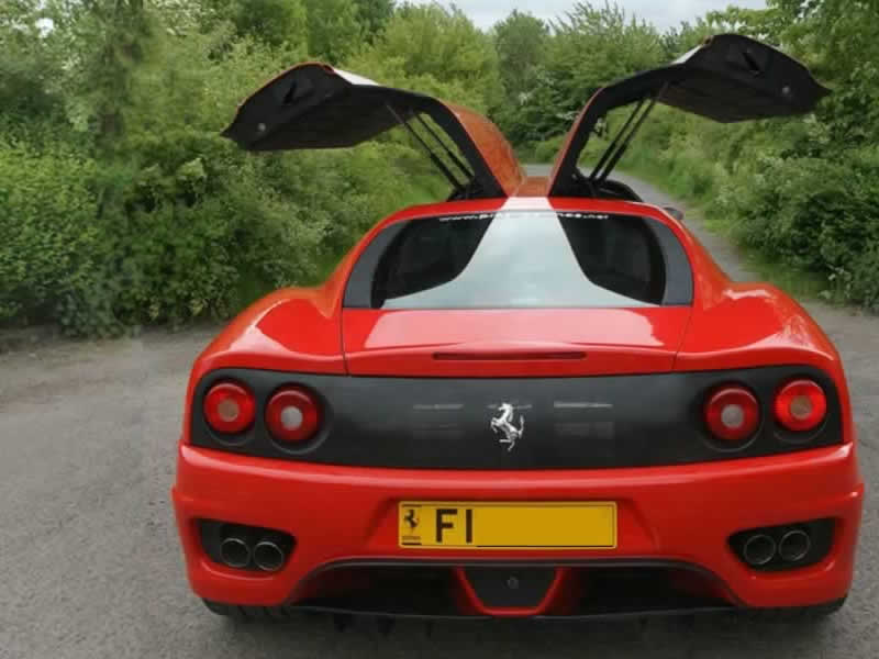 Red F1 Ferrari limo rear view with gullwing doors open